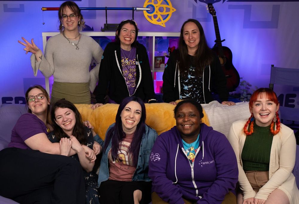 Fatales sitting on a yellow couch and posing 
