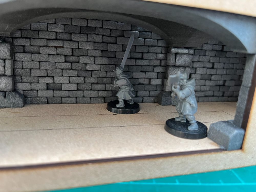A view from within the model sewer system, still in the process of being built. A couple of miniatures are visible for scale.