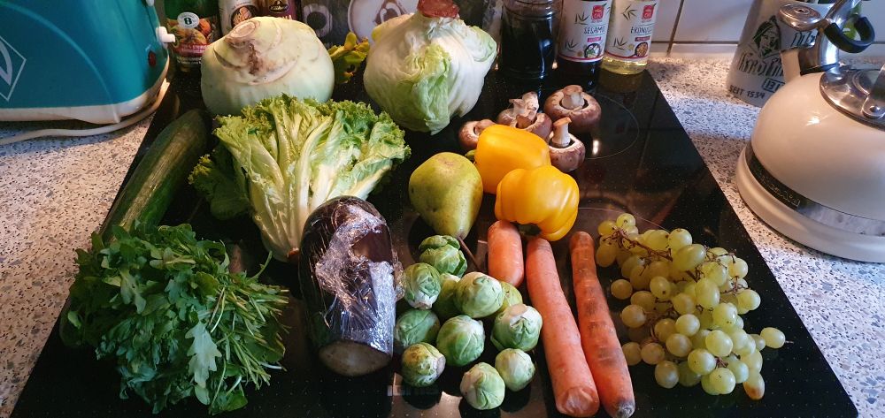 Ein ziemlich großer Kohlrabi, ein Salatkopf, ein Eisbergsalat, zwei Paprika, eine Birne, Rosenkohl, ein Bund Kräuter, Champignons, Karotten und eine Aubergine. 