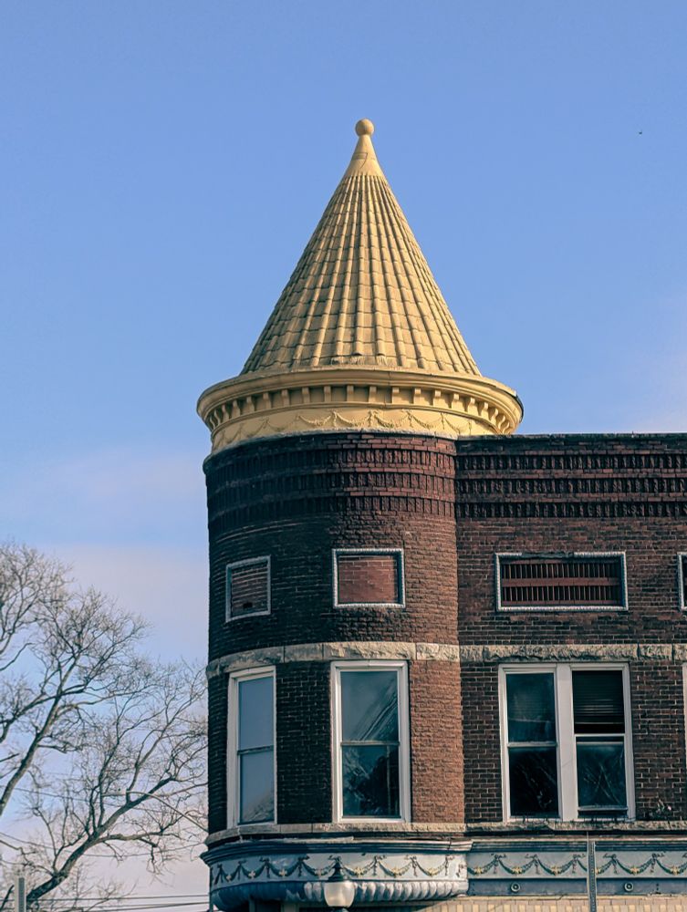 Photo of an old brick building with a nice golden spire roof