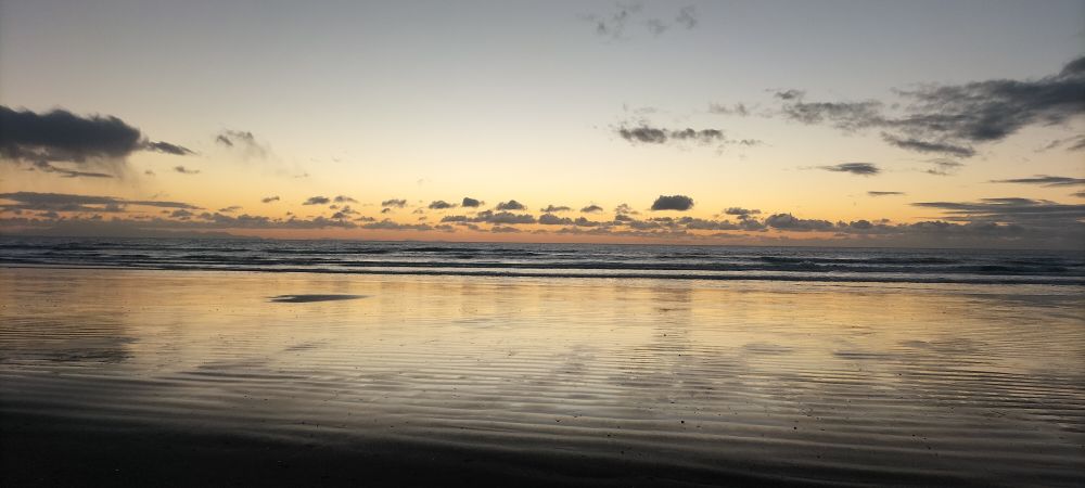 Paekakariki beach, silver and peach sand, sea, sky and relections