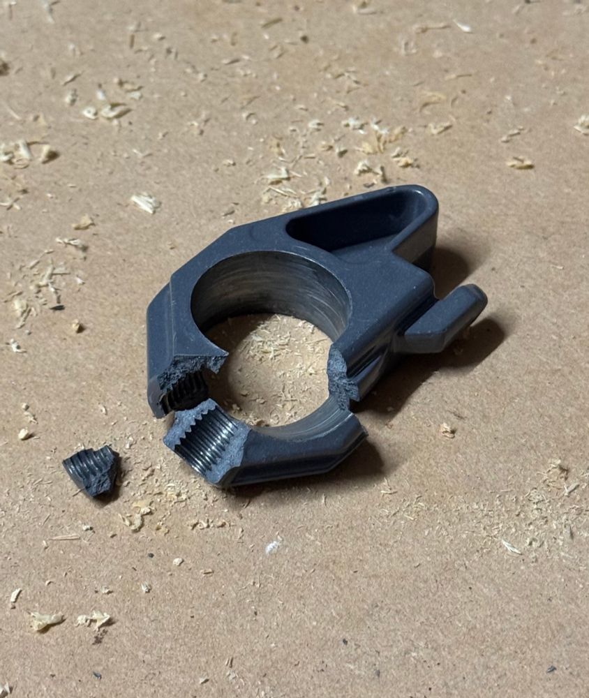 A broken die cast metal part from a drill press