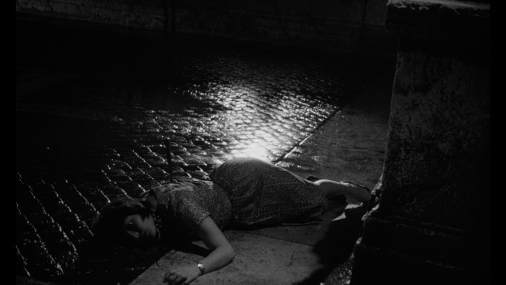 A dead woman's body lays on the ground of the Spanish Steps in Italy, with a knife still in her back [Film: The Girl Who Knew Too Much (1963)]
