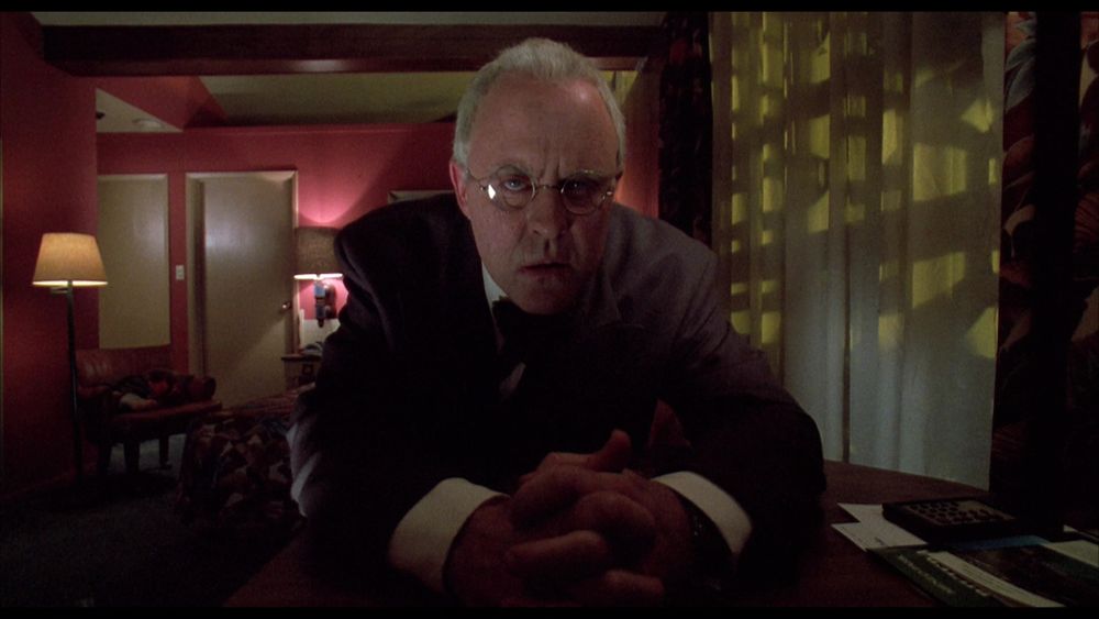 Dr. Nix (portrayal: John Lithgow) stares sternly into the camera [Film: Raising Cain]