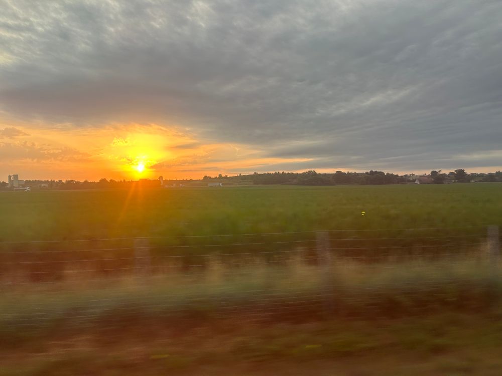 Le jour se lève. Paysage de champs depuis la fenêtre du train, vers 6h15. 