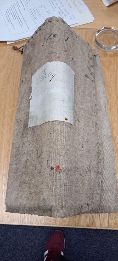 Ship's log for the Betsy, bound in sail cloth and buckled in the middle where it has been stored folded in half