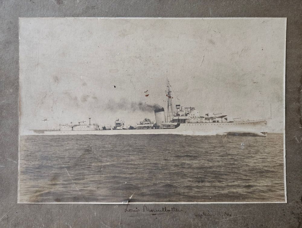 Print of estroyer at speed, mounted on card, with "Louis Mountbatten, Captain, R.N." handwritten beneath it. 