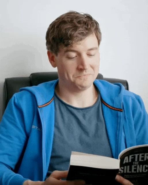 a man wearing a blue jacket is reading a book called after the silence