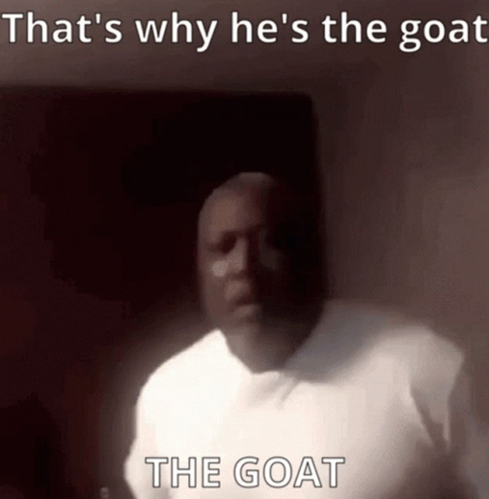 a man in a white shirt is saying that 's why he 's the goat and the goat is behind him .