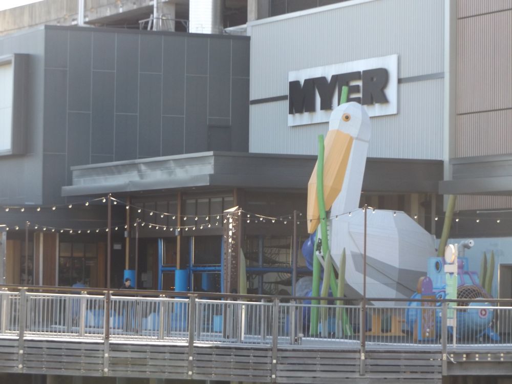 huge pelican statue at the plaza at Maroochydore on the sunshine coast - in front is the bridge over cornmeal creek, behind is a Myer sign 