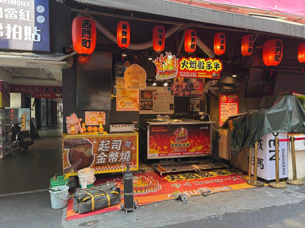 Lots of red in the photo, shop selling flame grilled beef, red paper lanterns decorating the place
