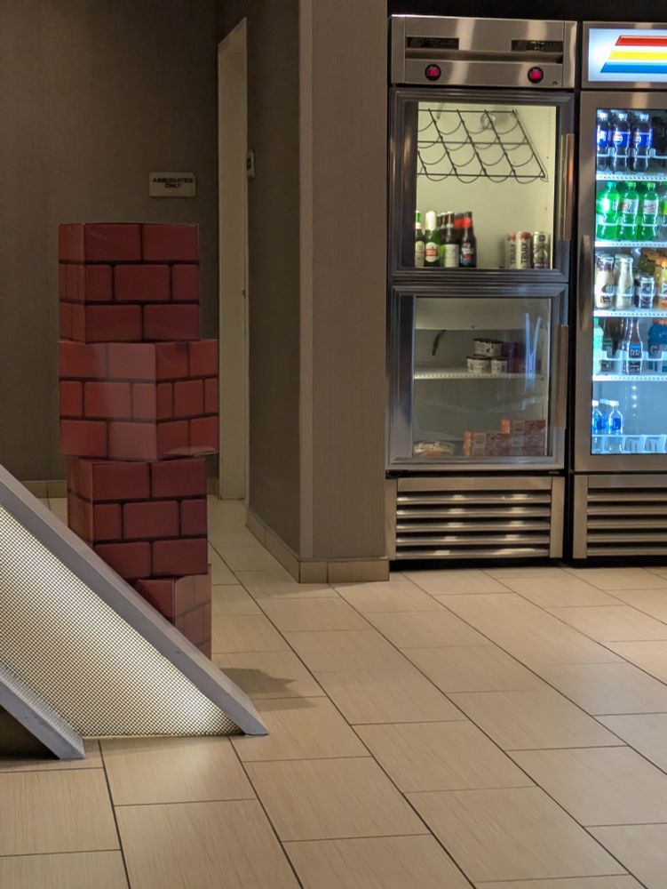 A stack of three brick blocks inside of a desolate and sterilized hotel lobby.