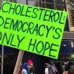 Sign at an anti-Trump protest during his first term that says,  "Cholesterol: Democracy's Only Hope"
