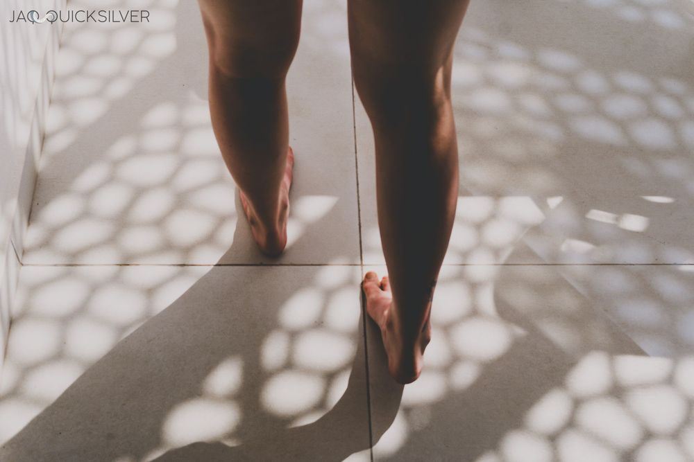 Same lighting as previous, but the shot shows Jaq's calves and feet as they walk through the patterned light.