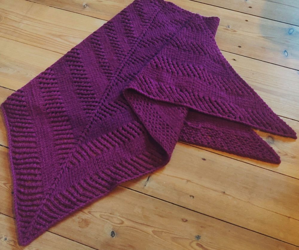 A photo of a purple triangle shawl. Hand knitted✋