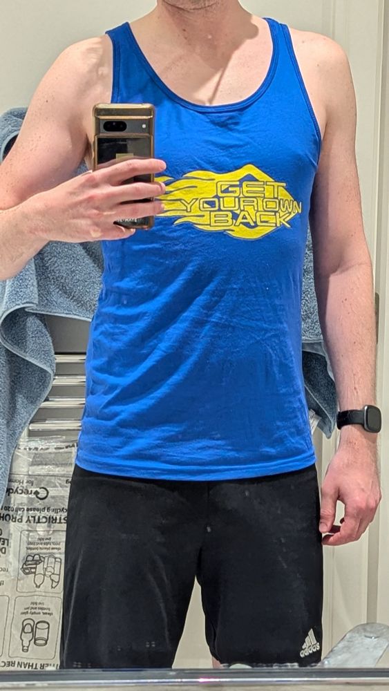 Guy wearing a blue Get Your Own Back Tank top 