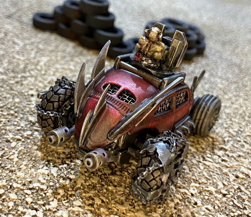 VW beetle modified for Gaslands with Orky wheels spikes and a grinning Ork firing a roof mounted flamethrower 