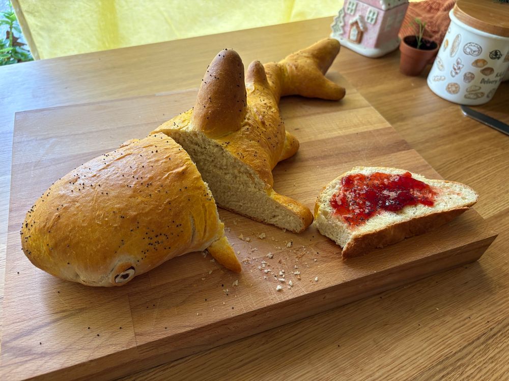 Sliced bread loaf shaped like a lemon shark with a slice on the side topped with strawberry jam