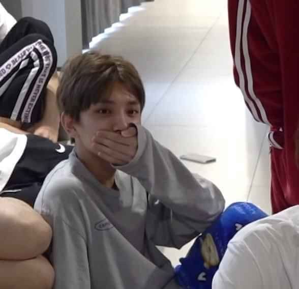 Joshua sitting with his hand over his mouth