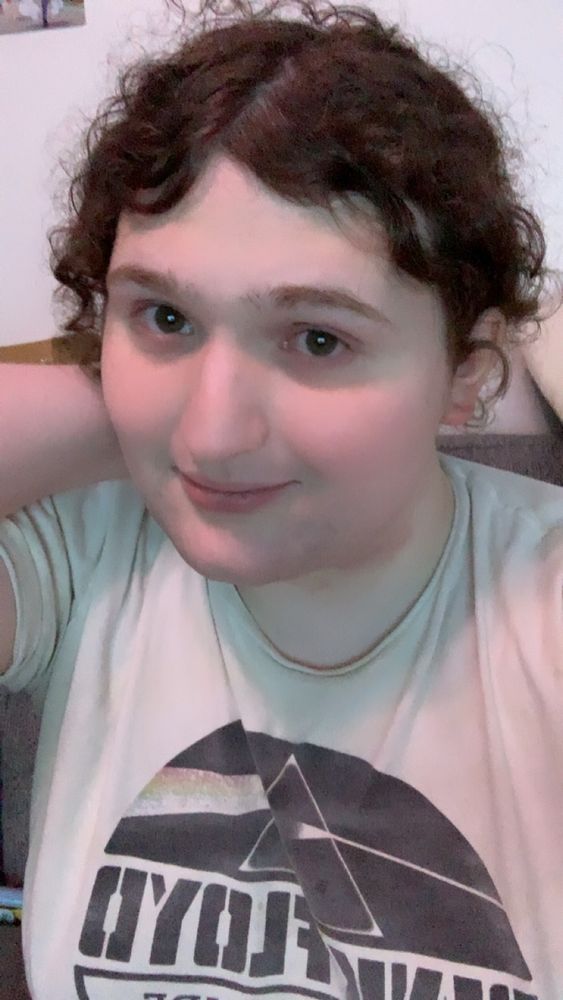 Gwen smiling at the camera while holding her hair back