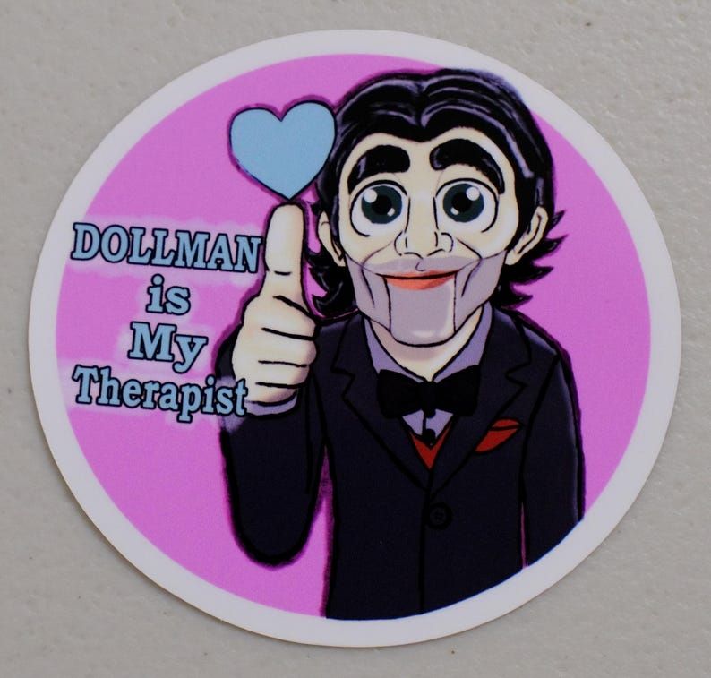 A cartoon drawing of Dollman from Death Stranding 2. He is doing a thumbs up and a blue heart is appearing above him. Text says Dollman is my therapist