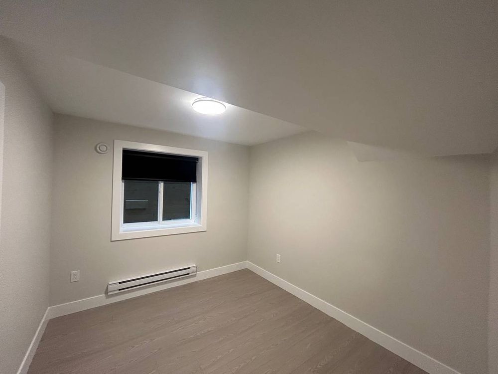 photo of the bedroom, window has view of a concrete wall that seems to be directly on the other side with about five inches of space