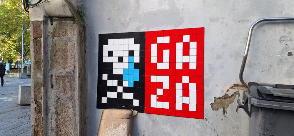 Un xerión de teselas brancas sobre fondo negro cunha bágoa azul ao carón do nome de Gaza, perto dalgunha praza de A Coruña. 