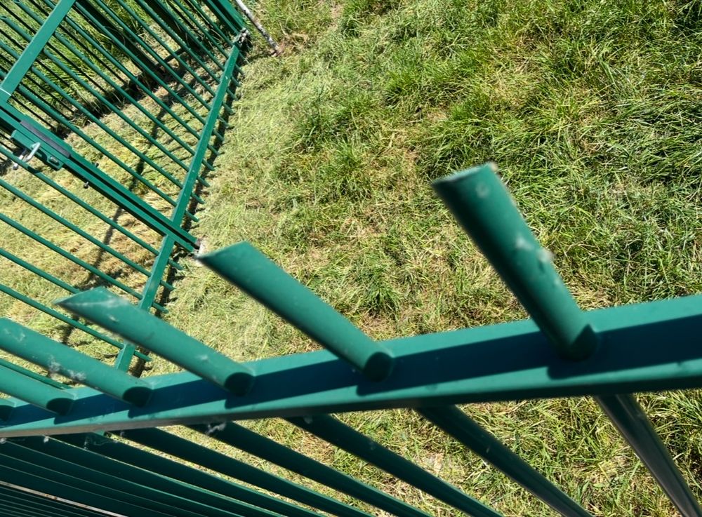 Groen hek en gras in weiland.