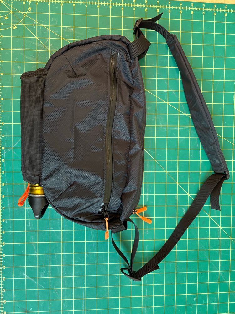 A black sling bag on a cutting board