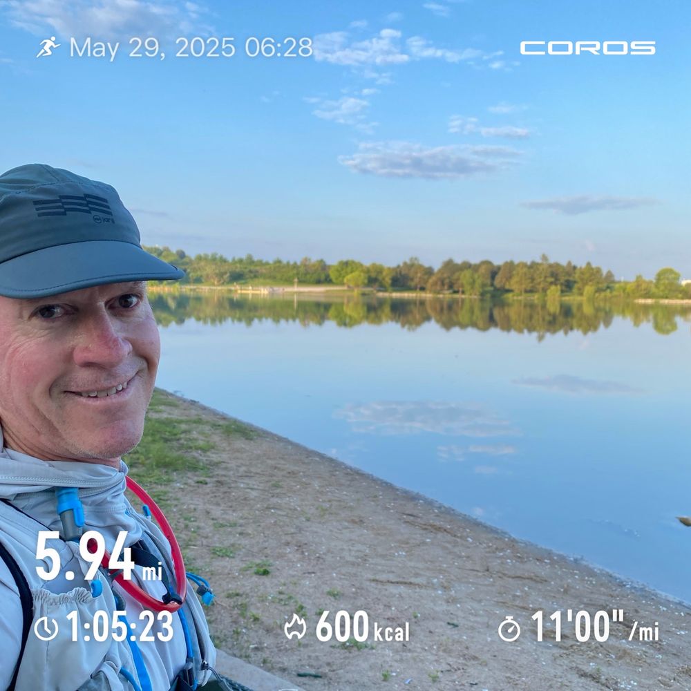Runner posing before a lake. 
