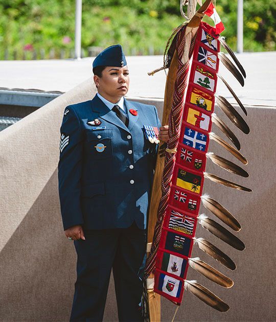 Indigenous woman in uniform holding flags 