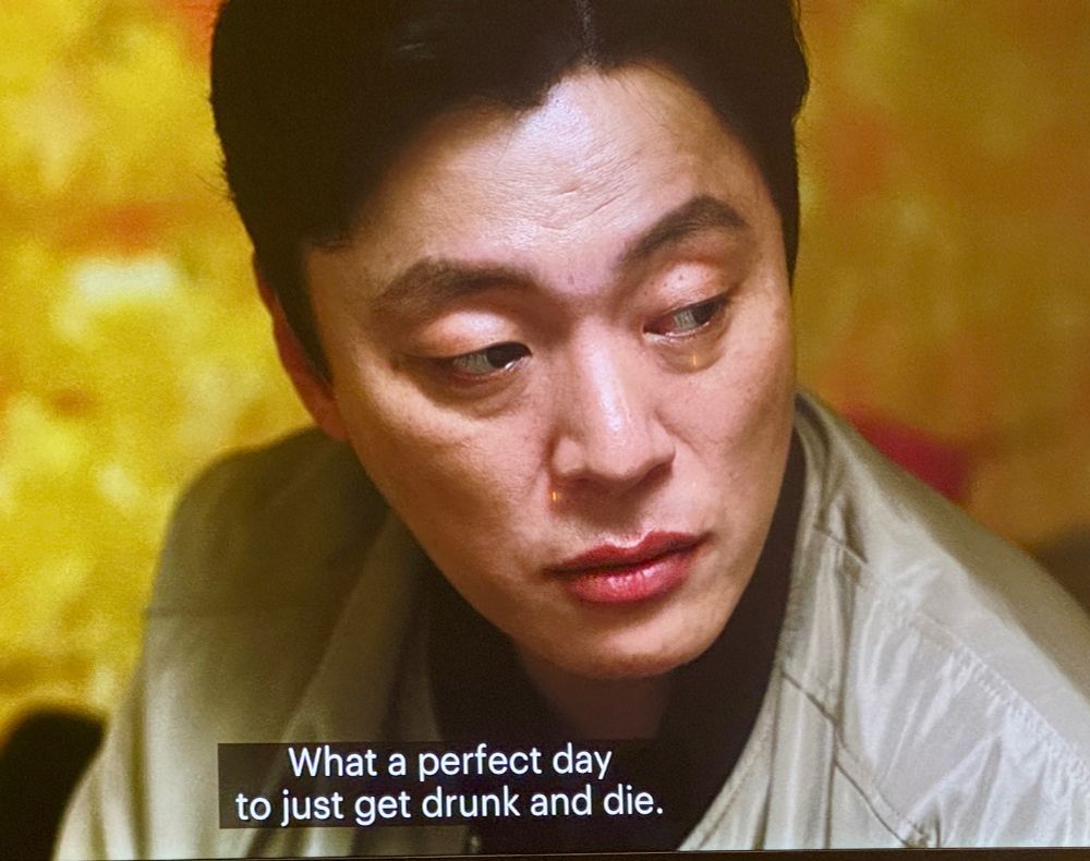 Close-up of disturbed man. Closed-caption says, "What a perfect day to get drunk and die." 