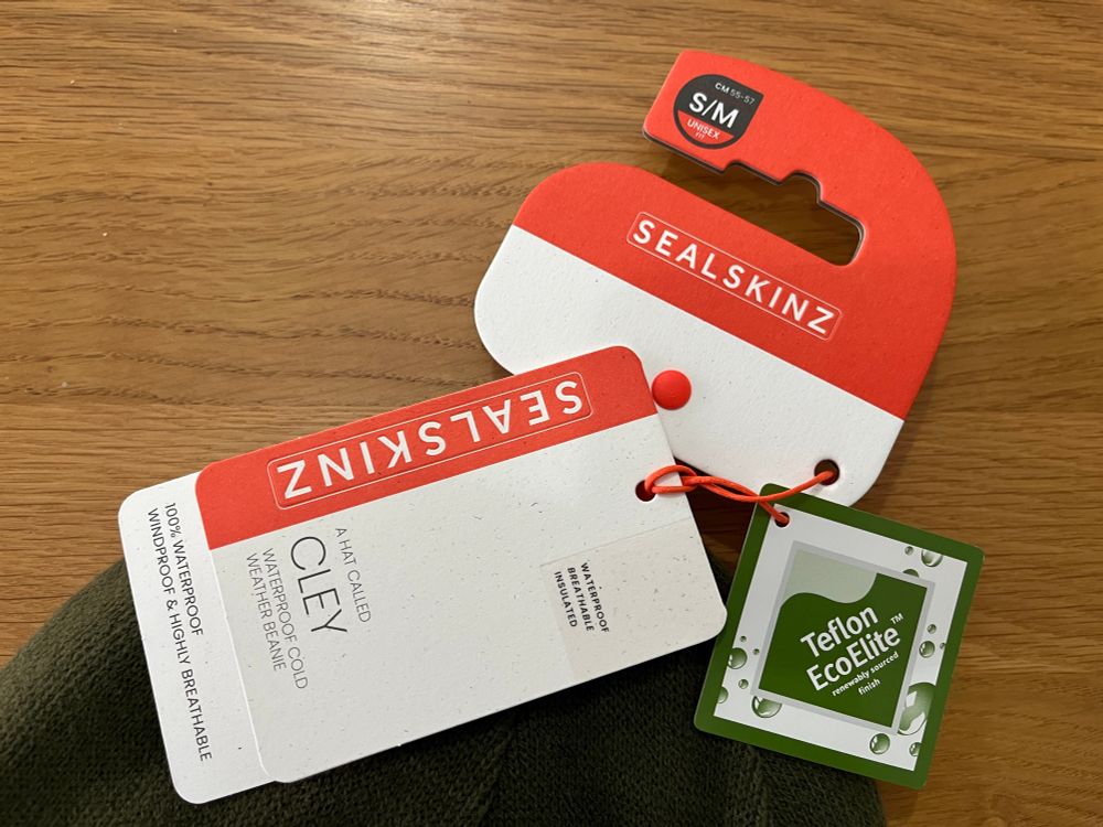 Tags from Sealskinz Cley waterproof, fleece-lined beanie in green. 