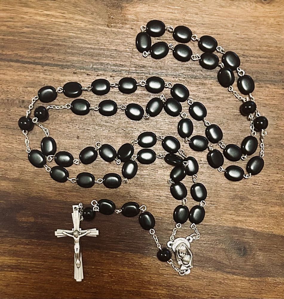 A rosary of flat black beads with a silver crucifix 