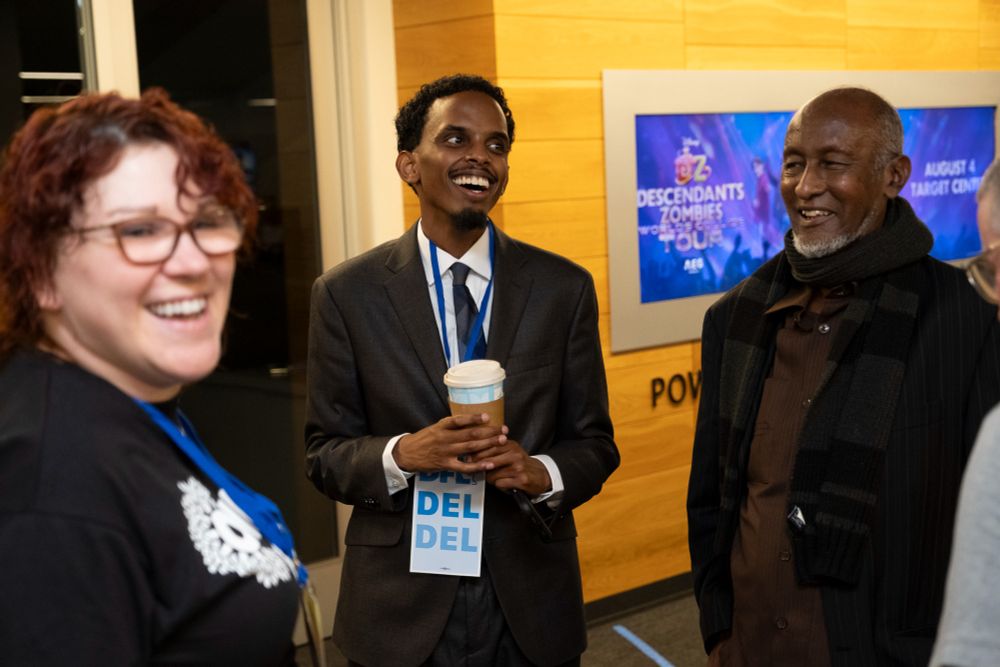 Omar Fateh smiles alongside Convention attendees.
