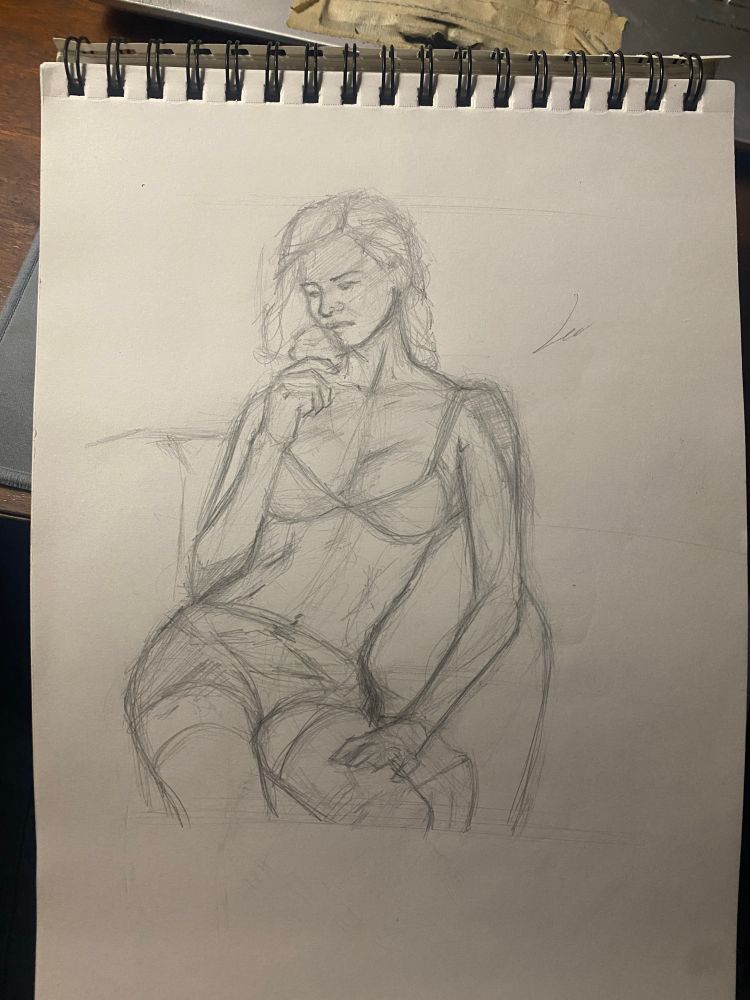 Woman reclining on a sofa, holding a flower and looking at it wistfully