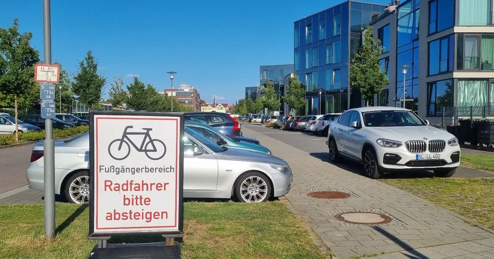 Schild vor einem Parkplatz Fußgängerbereich Radfahrer absteigen