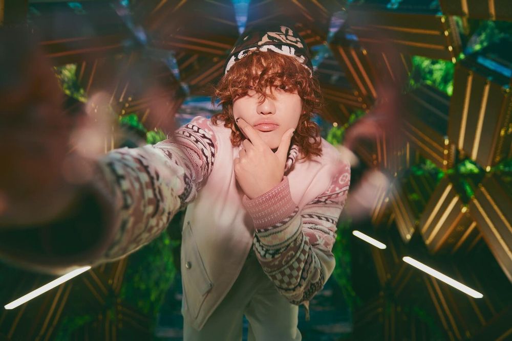 Minghao in caramel curly hair, a hat and pink sweater looking cute