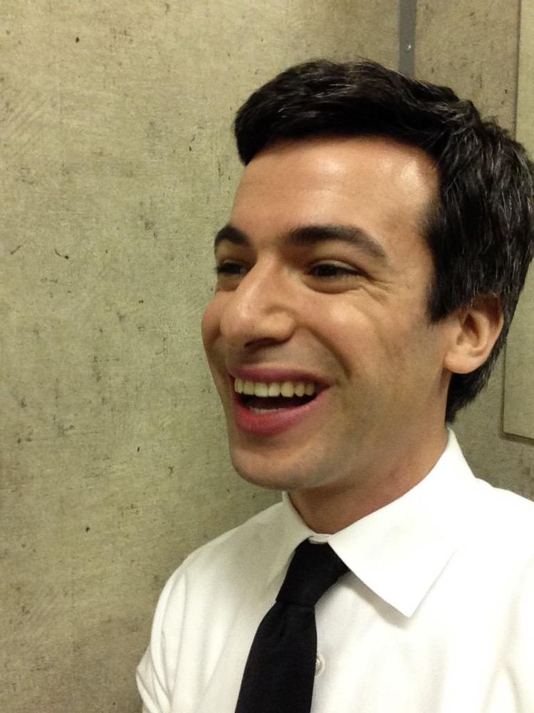 Nathan Fielder talking to his friends just out of frame, laughing too. 