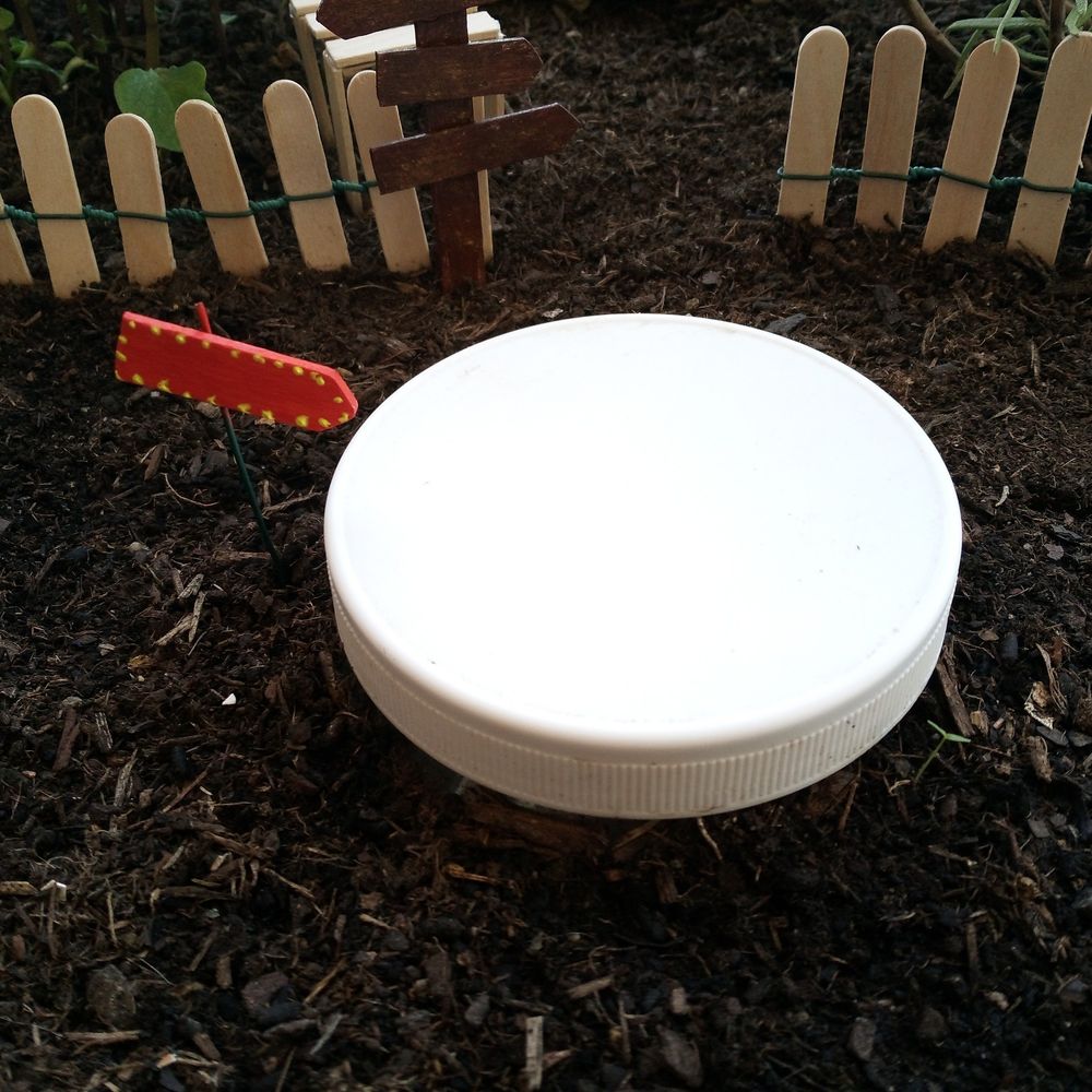 Photo rapprochée du composteur avec la flèche du trou vers le monde de la magie dans les sims 1 