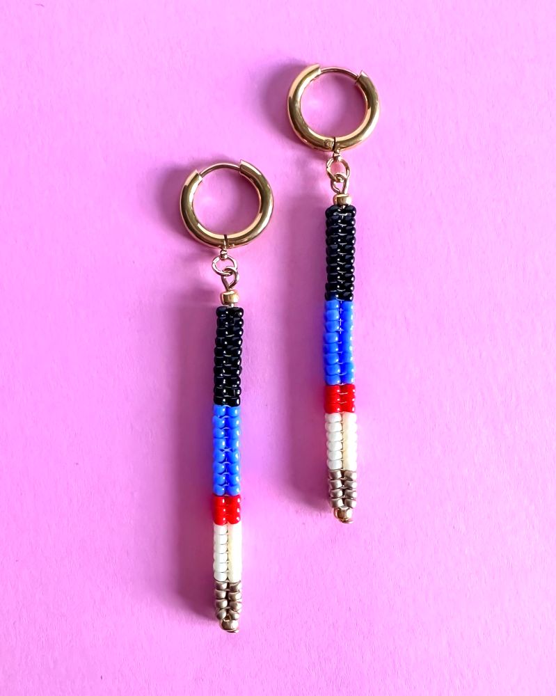 Boucles d’oreilles pendantes tissées à la main avec des petites perles colorées en verre. Le tissage forme un « tube » accrochée à une mini créole or. 
Les 2 boucles sont posées sur un fond rose 