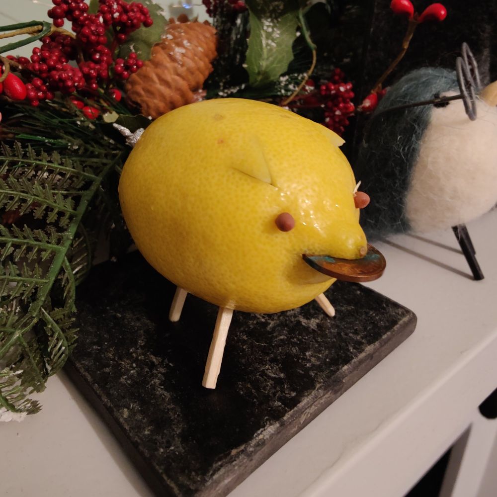 A fresh Lemon Pig with a penny in its mouth on a Christmassy mantlepiece. 