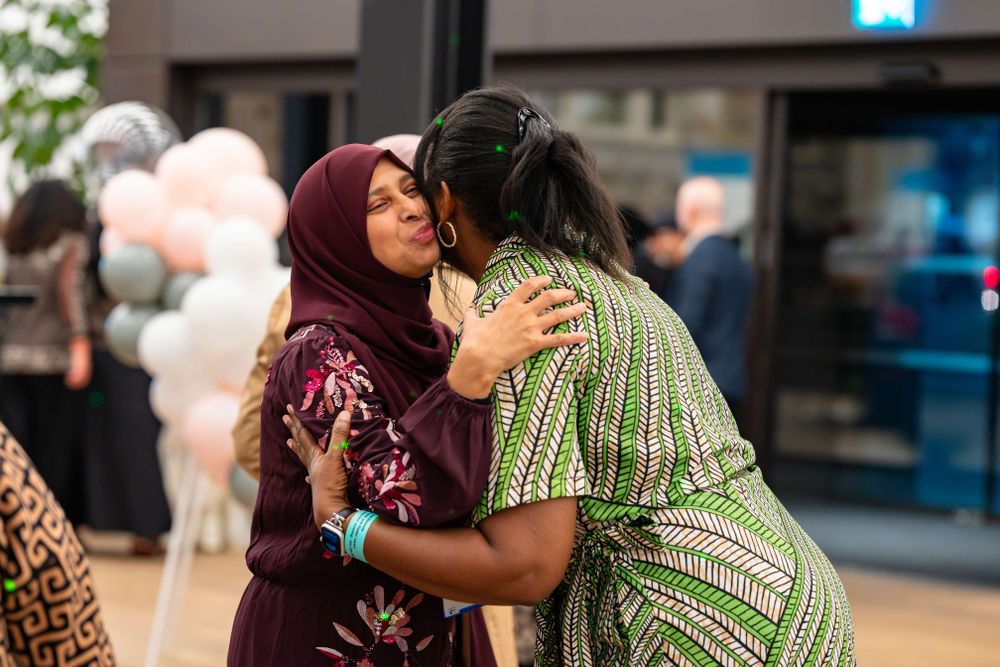 two women greet each other with a kiss on the cheek