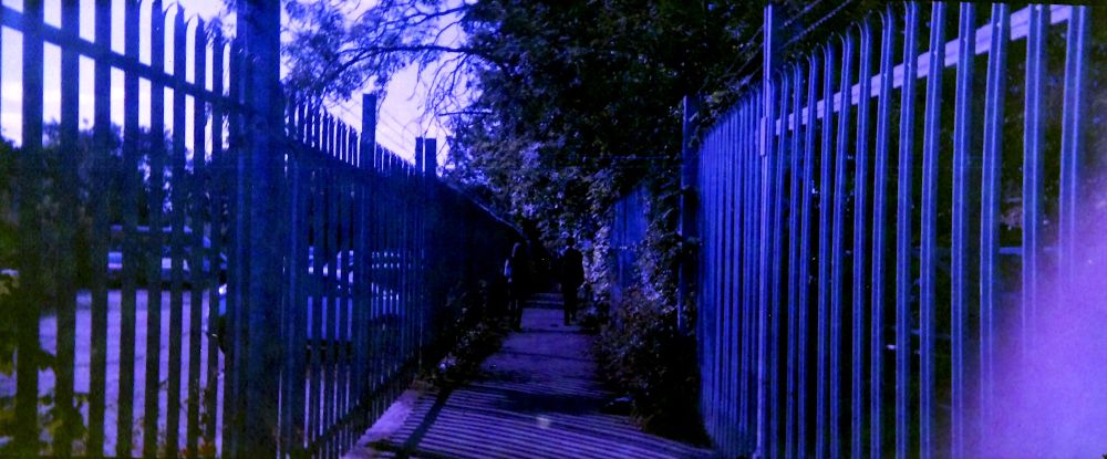 A mysterious figure walking down an alleyway. Shot on very expired film. 