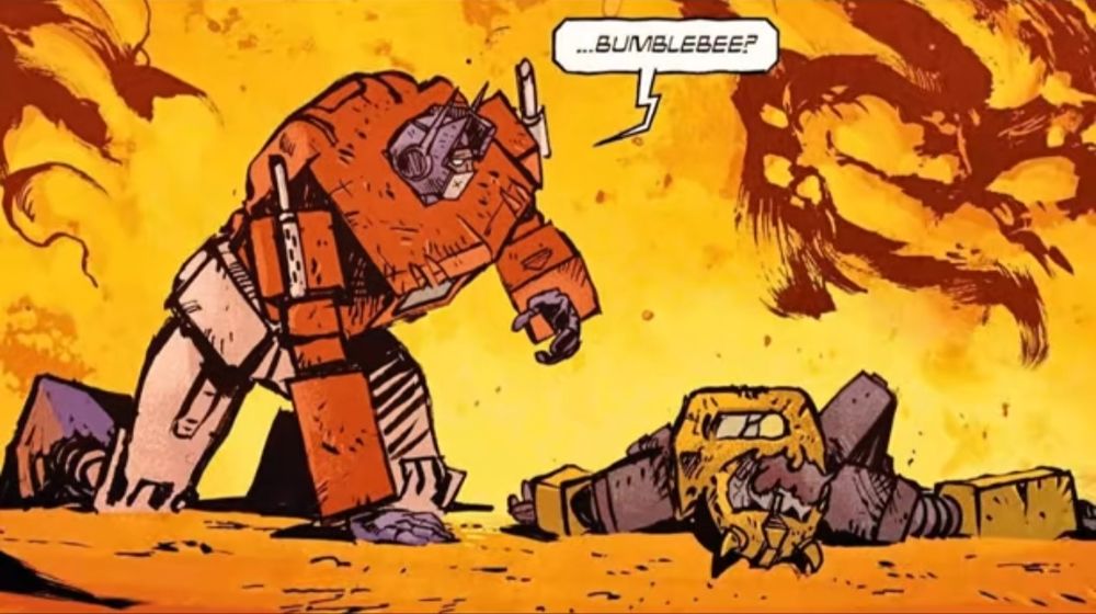 Optimus prime crawls towards a dead bumblebee with his face missing, saying "...bumblebee?" Fire is in the background. 