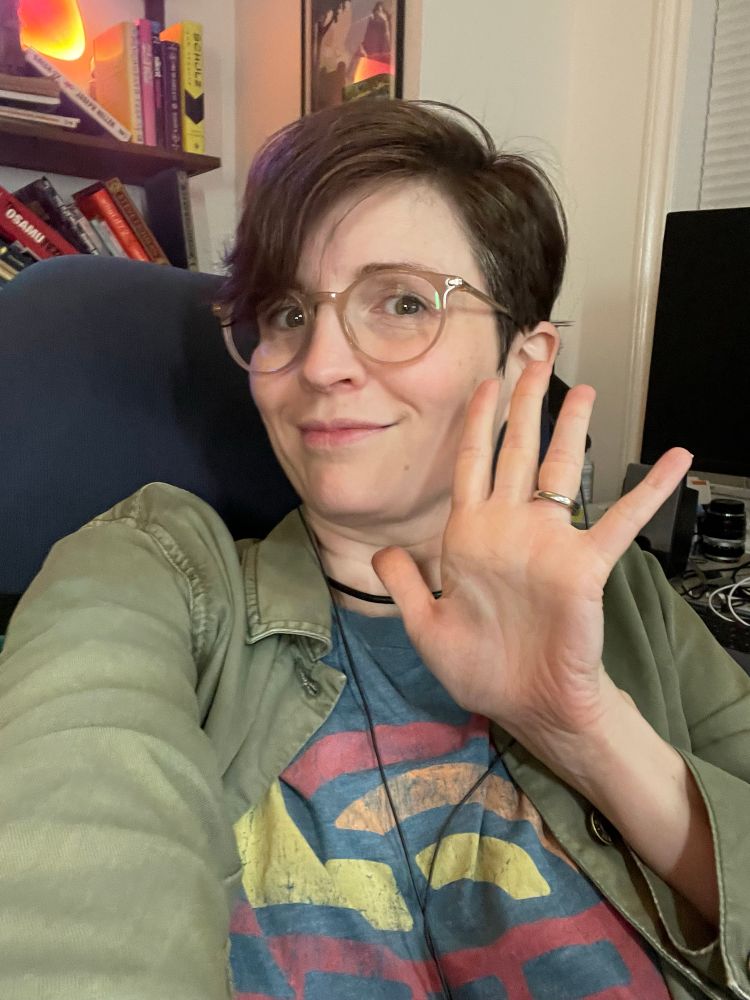 Woman who is bad at taking selfies waving in a selfie