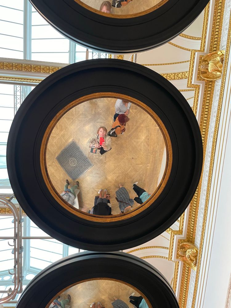 My looking up into a circular mirror hanging from the ceiling. 