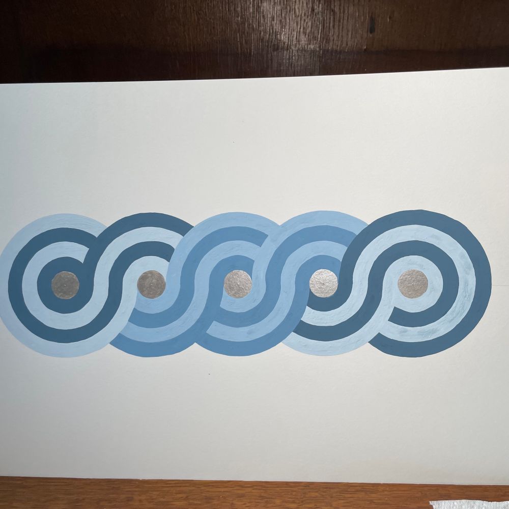 A pattern of five interlocking circles, painted in shades of blue with silver centres. 