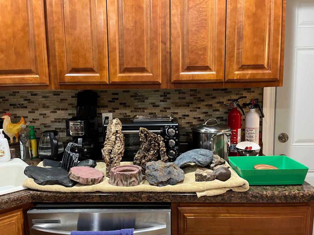 Kitchen counter covered with an array of gecko decor drying on a large towel