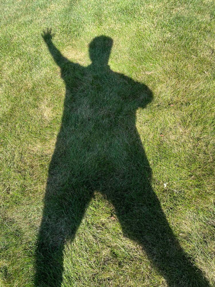 Silly person’s shadow on the grass doing a dramatic dance move